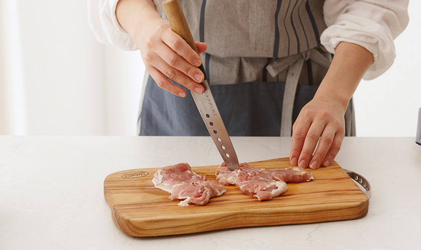 닭다리살을 넓게 펼쳐 칼집을 넣은 후 간장과 청주를 뿌려 밑간한다.