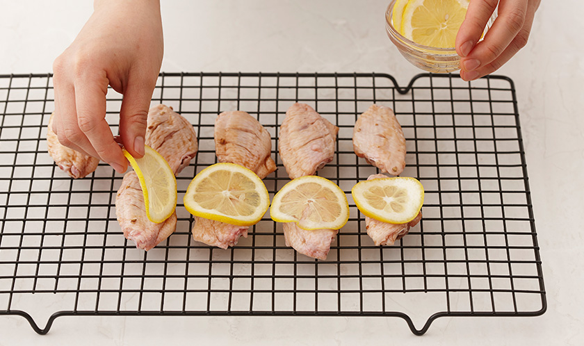 오븐팬에 닭날개를 올리고 얇게 슬라이스한 레몬을 위에 올린다.