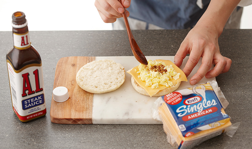 잉글리시 머핀 사이에 치즈, 2, A1 스테이크 소스를 넣는다.