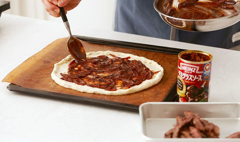 피자도우를 넓게 밀고 3을 펴 발라 180℃로 예열한 오븐에서 10분간 굽는다.