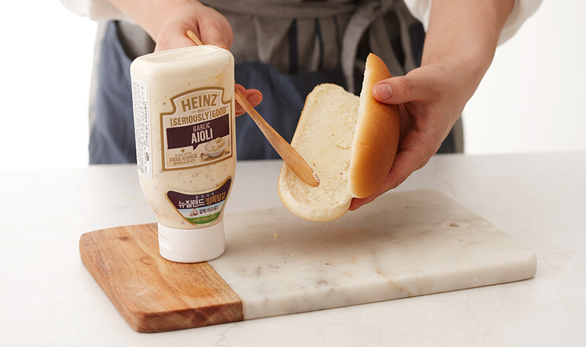 핫도그빵을 반 가르고 단면에 아이올리를 바른다.