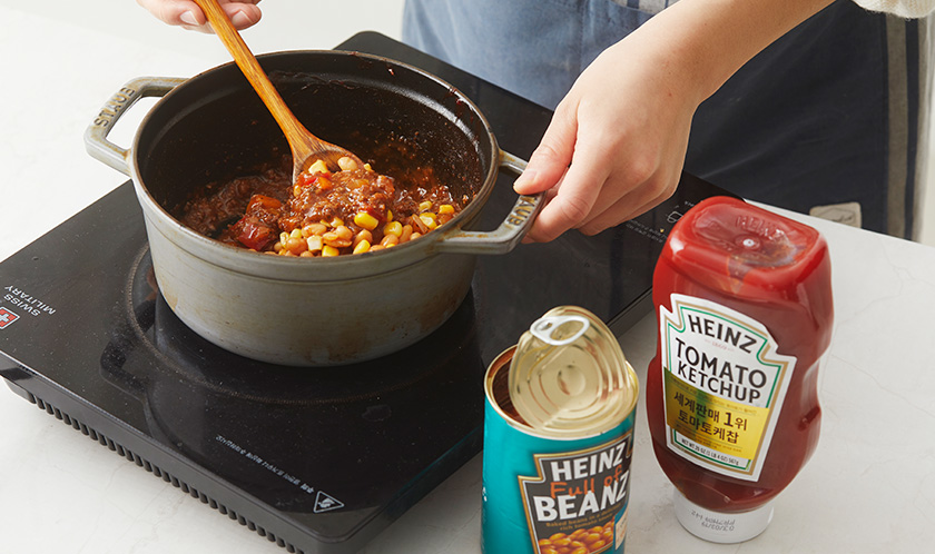 베이크드빈스, 토마토, 옥수수를 넣고 한소끔 끓인 후, 불을 줄여 10분간 뭉근하게 끓인다. 